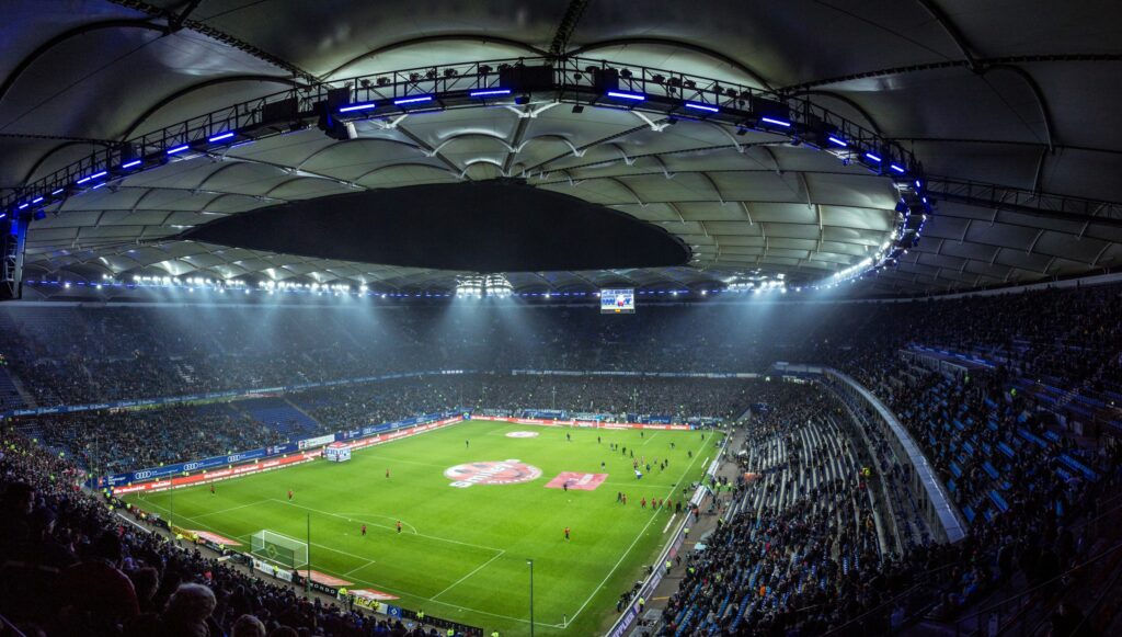 Packed football stadium under floodlights